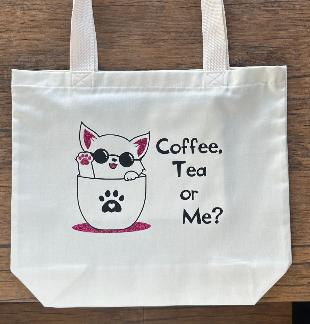White tote bag with a cat graphic and text 'Coffee, Tea or Me?' on a wooden surface, handmade cat tote bag made in the UK, gift for cat lovers