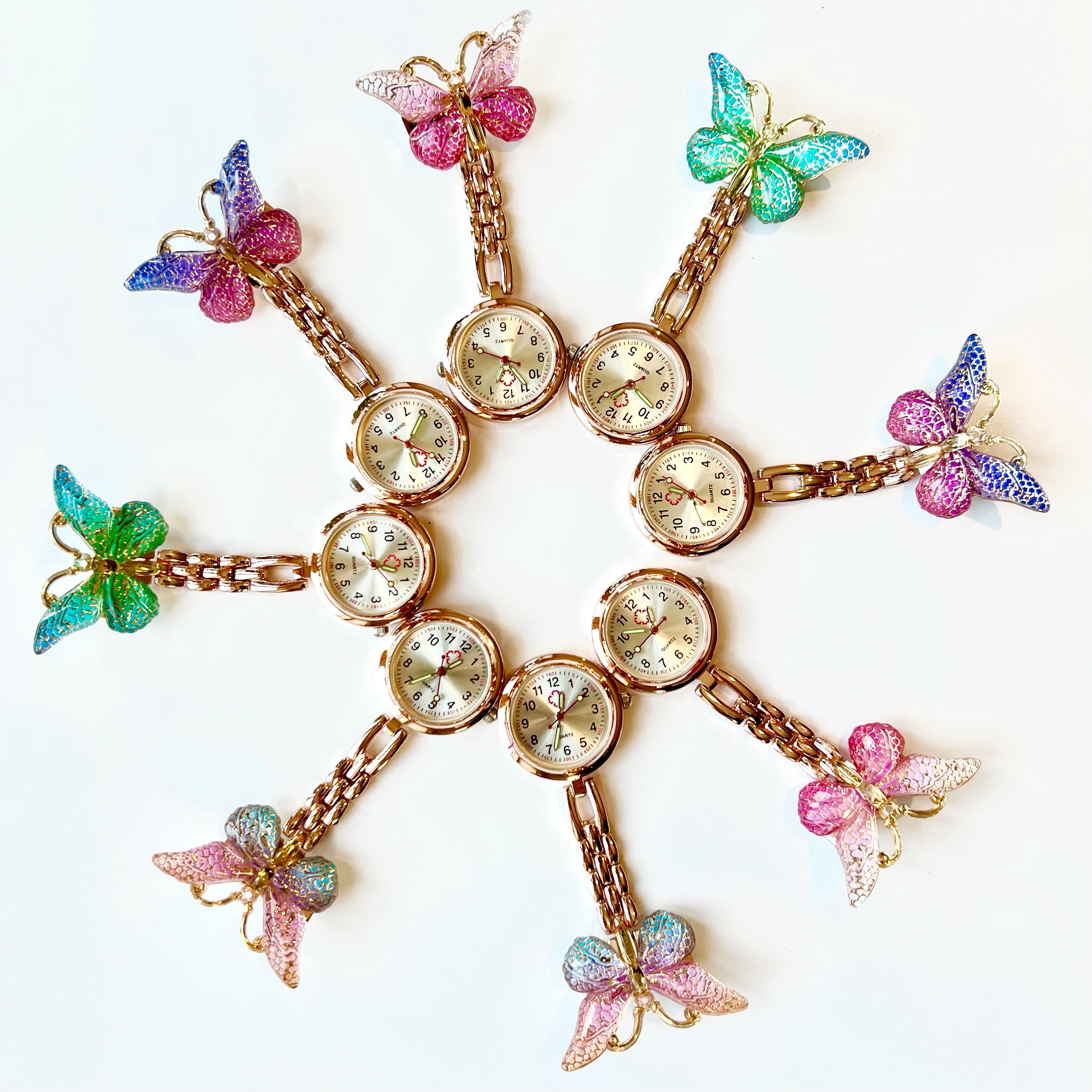 Decorative watch with butterfly fob watch charms on a white background