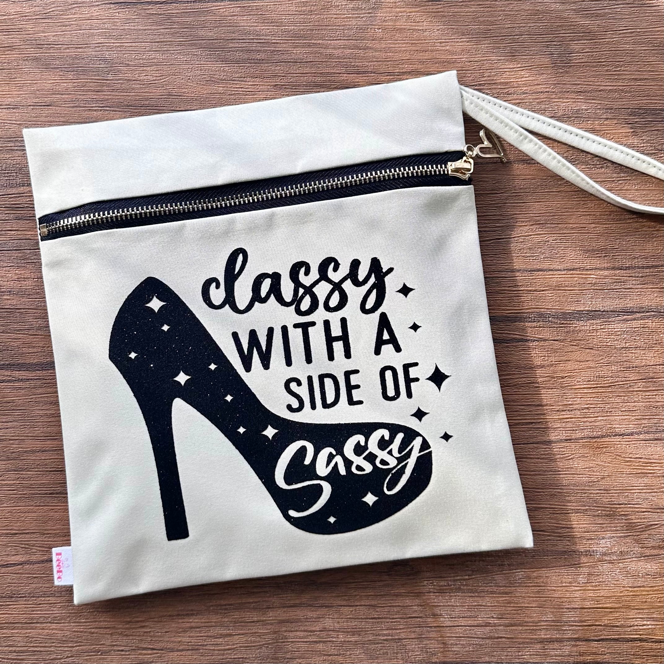 White pouch with black high heel design and text on a wooden surface
