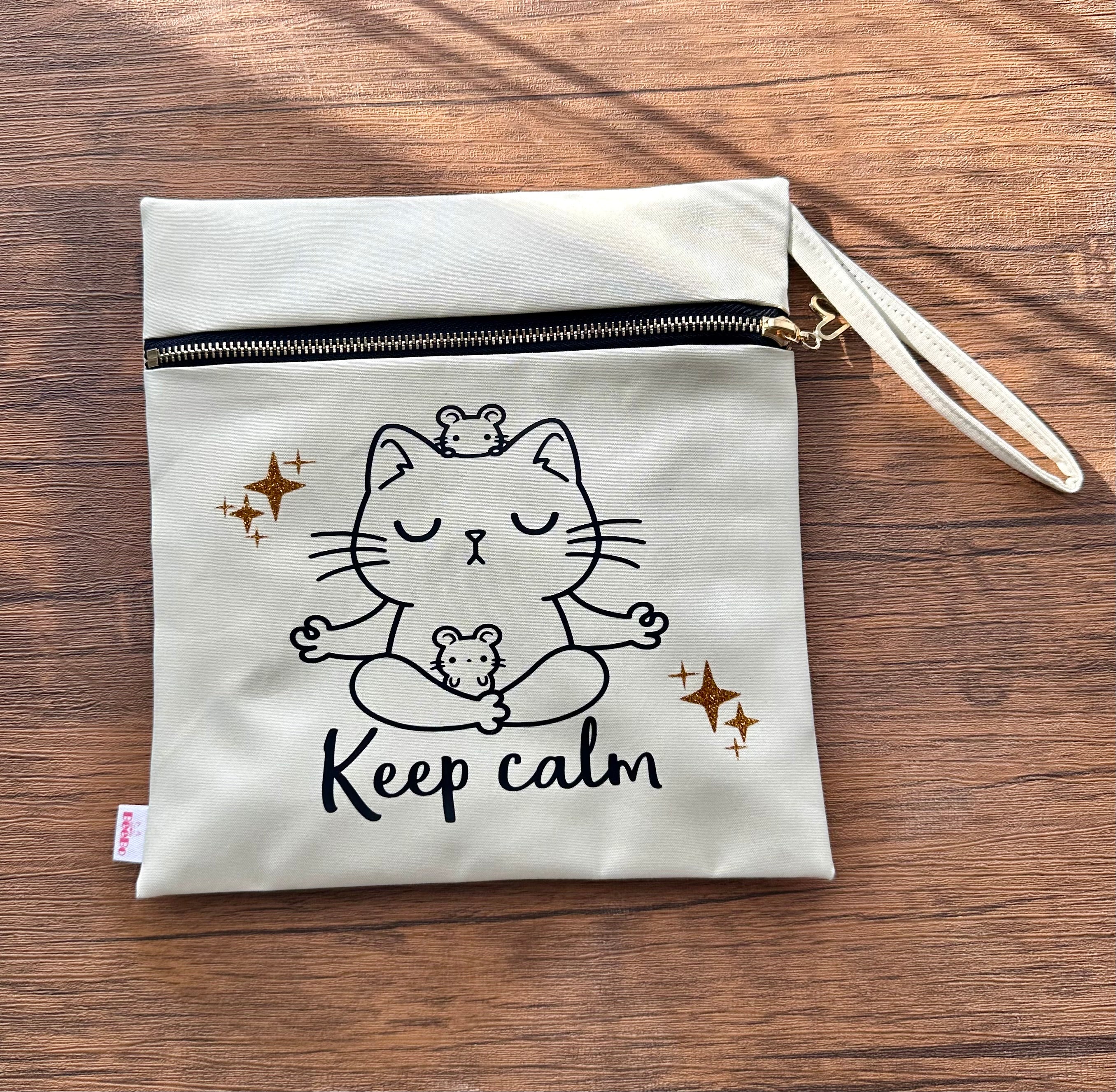 Canvas pouch with a cat illustration and 'Keep calm' text on a wooden surface