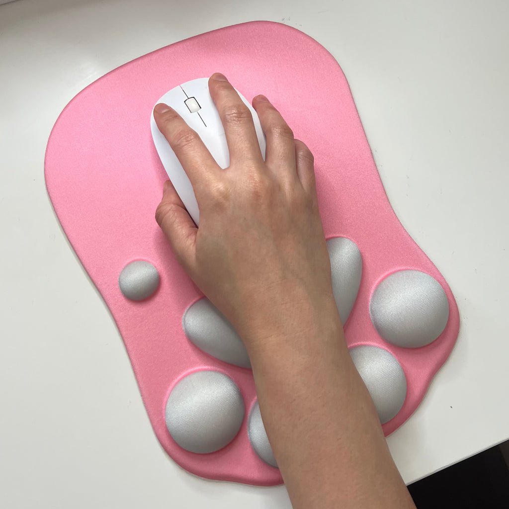 Hand using a computer mouse on a pink wrist rest with gray nodes. Cat paw mouse pad cute pink