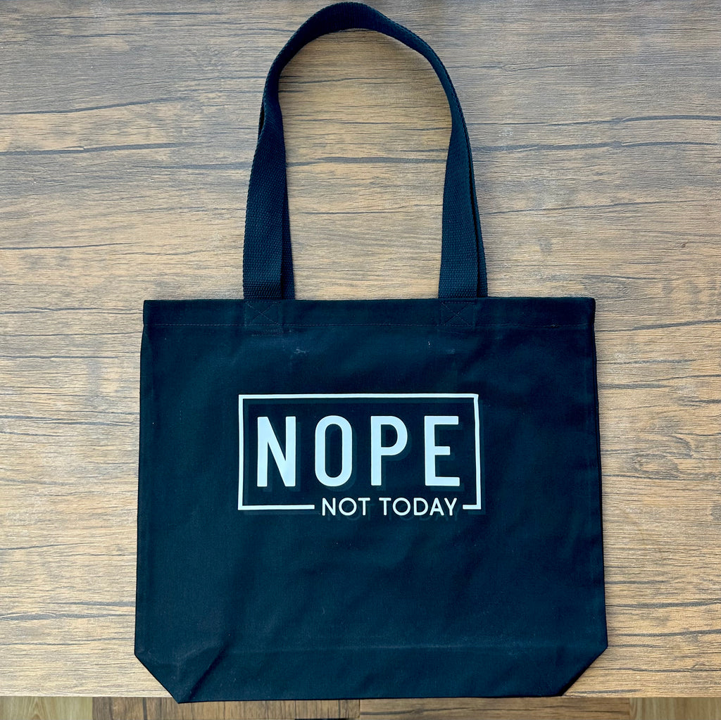Black tote bag with 'NOPE NOT TODAY' text on a wooden surface