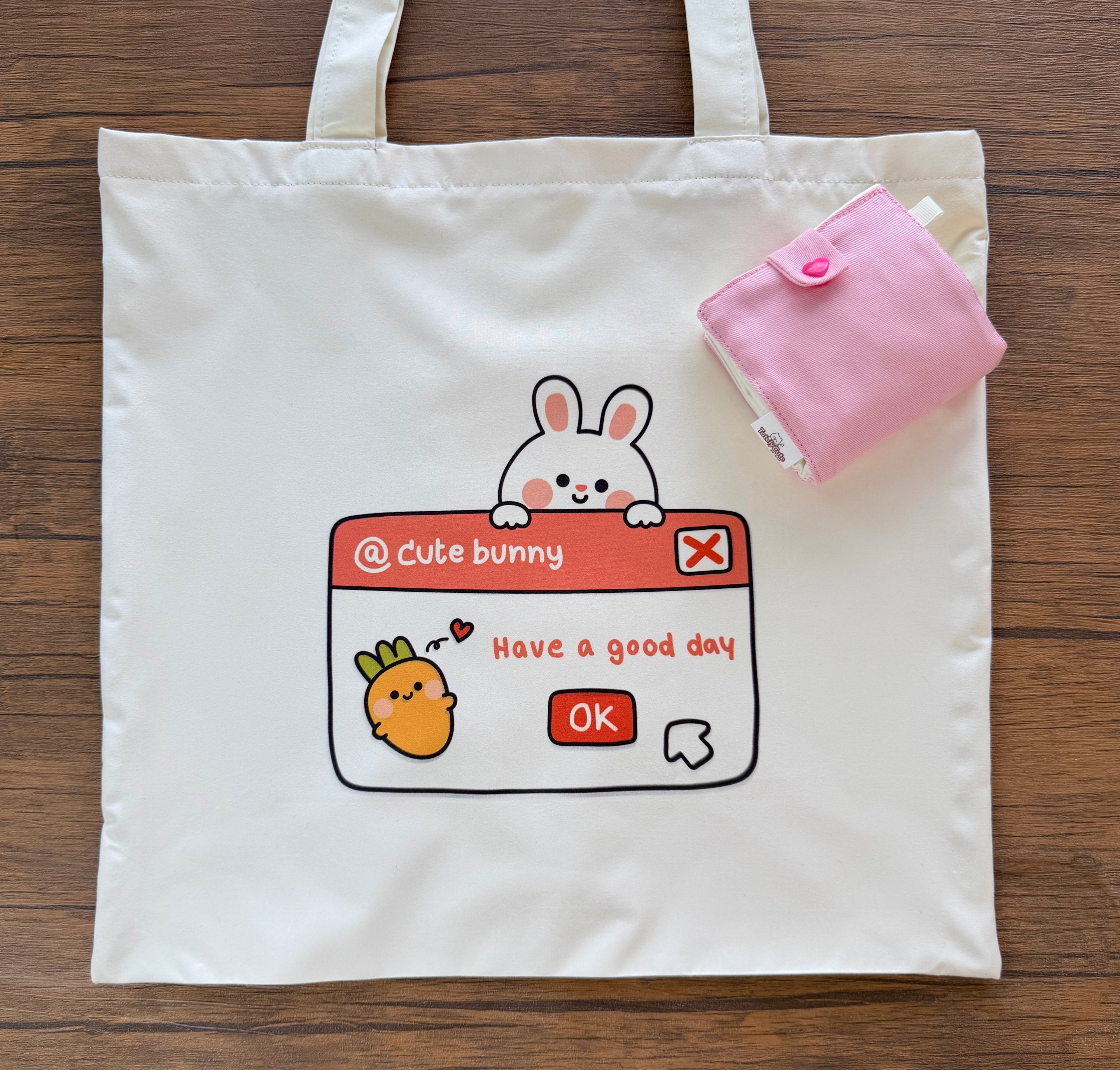 Tote bag with cartoon design and pink pouch on a wooden surface