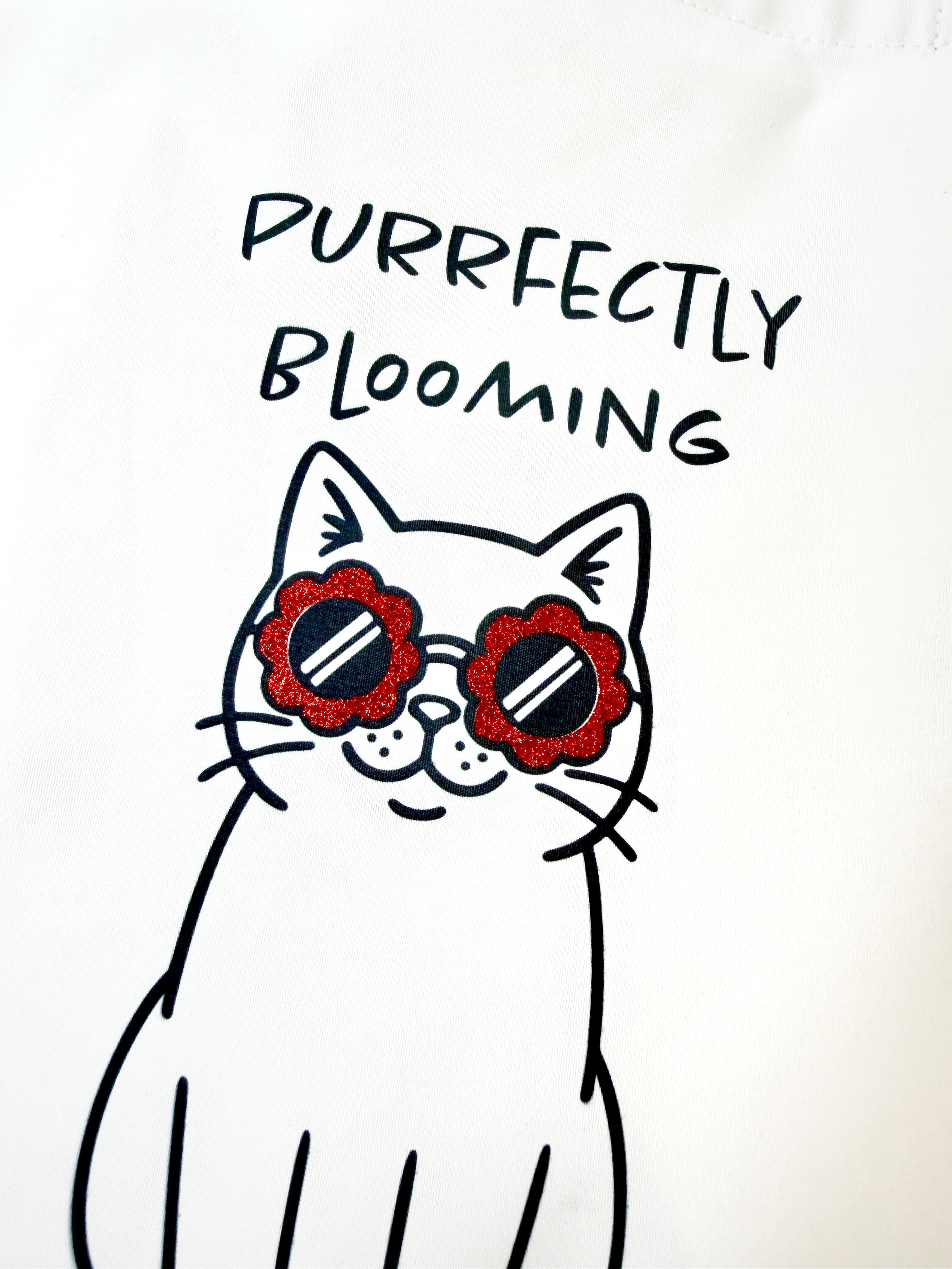 Cartoon cat wearing flower sunglasses with 'Purrfectly Blooming' text on a white background