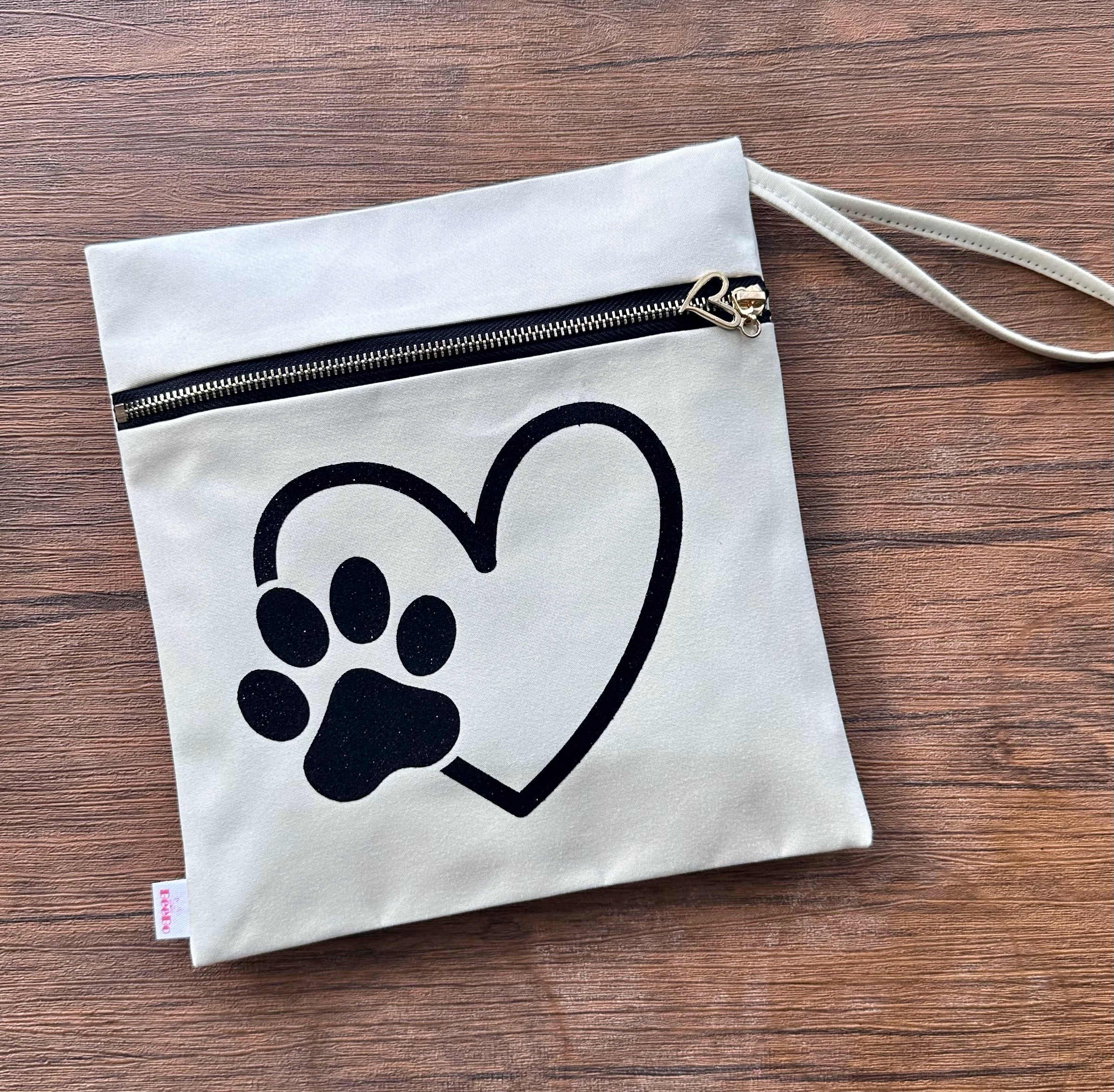 Canvas pouch with a heart and paw print design on a wooden surface