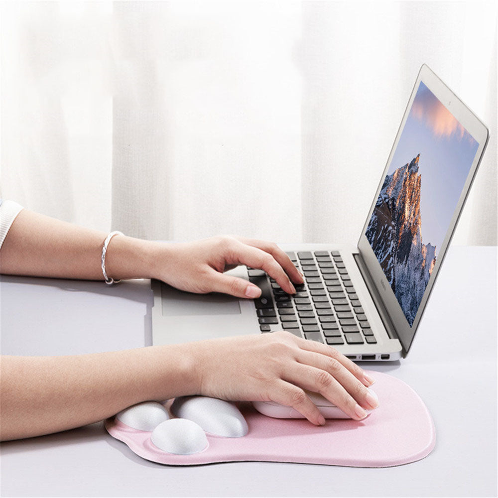 Person using a laptop with a pink wrist rest on a white surface