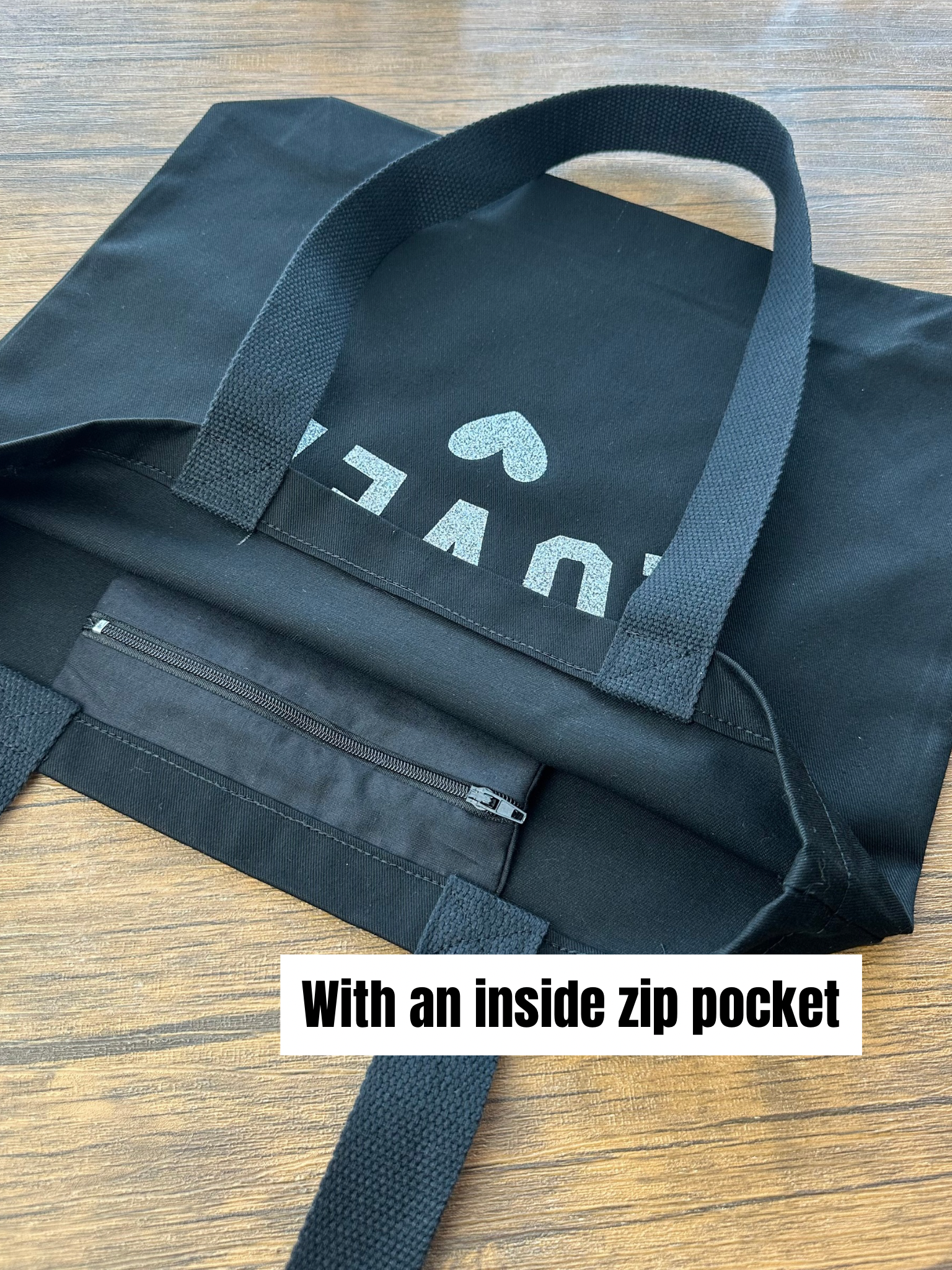 Black bag with a visible brand logo on a wooden surface