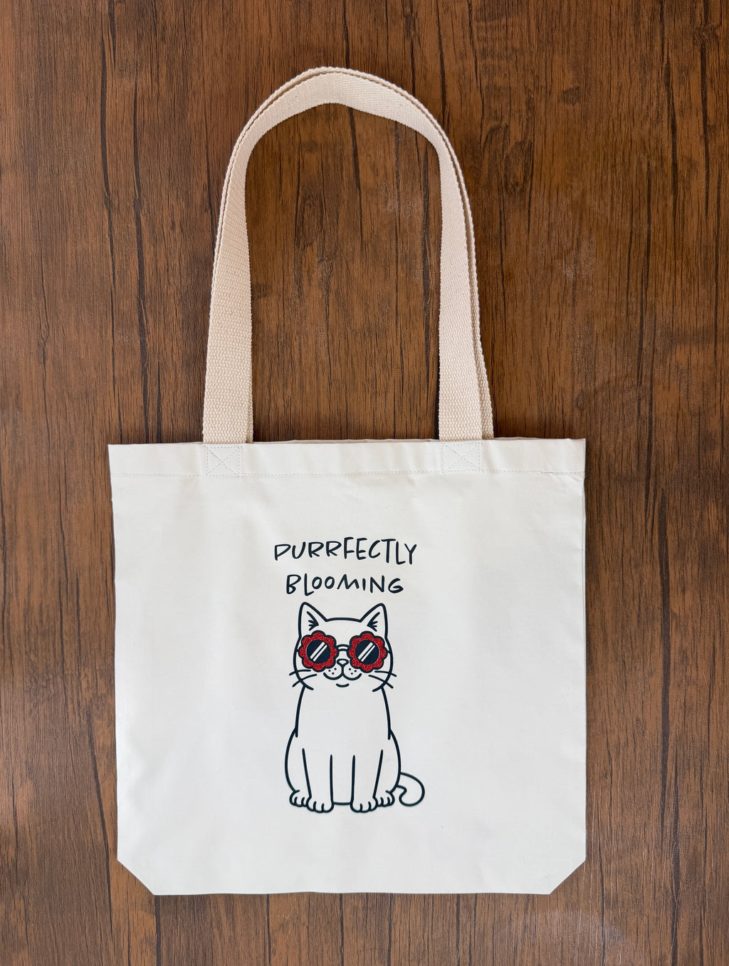 Tote bag with a cat illustration and text on a wooden surface, cute gift for her, gift ideas UK, cat lover