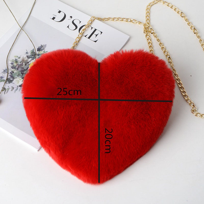 Red heart-shaped bag with gold chain and measurements on a white background