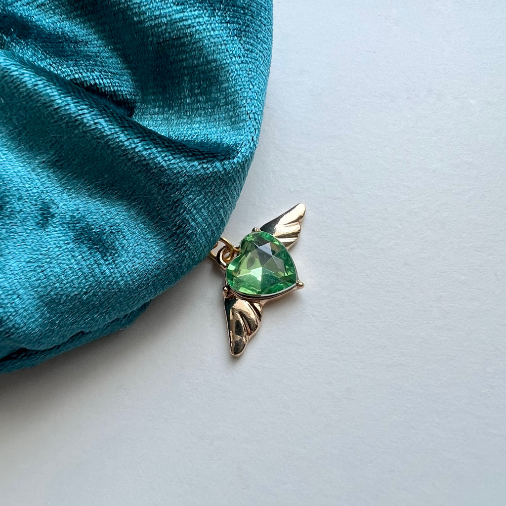 Green gemstone earring with gold setting on a white background
