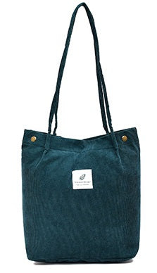 Teal tote bag with a visible brand label on a white background