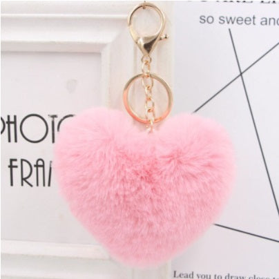 Pink heart-shaped fluffy keychain on a white background