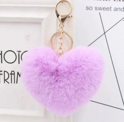 Purple heart-shaped fluffy keychain on a light background